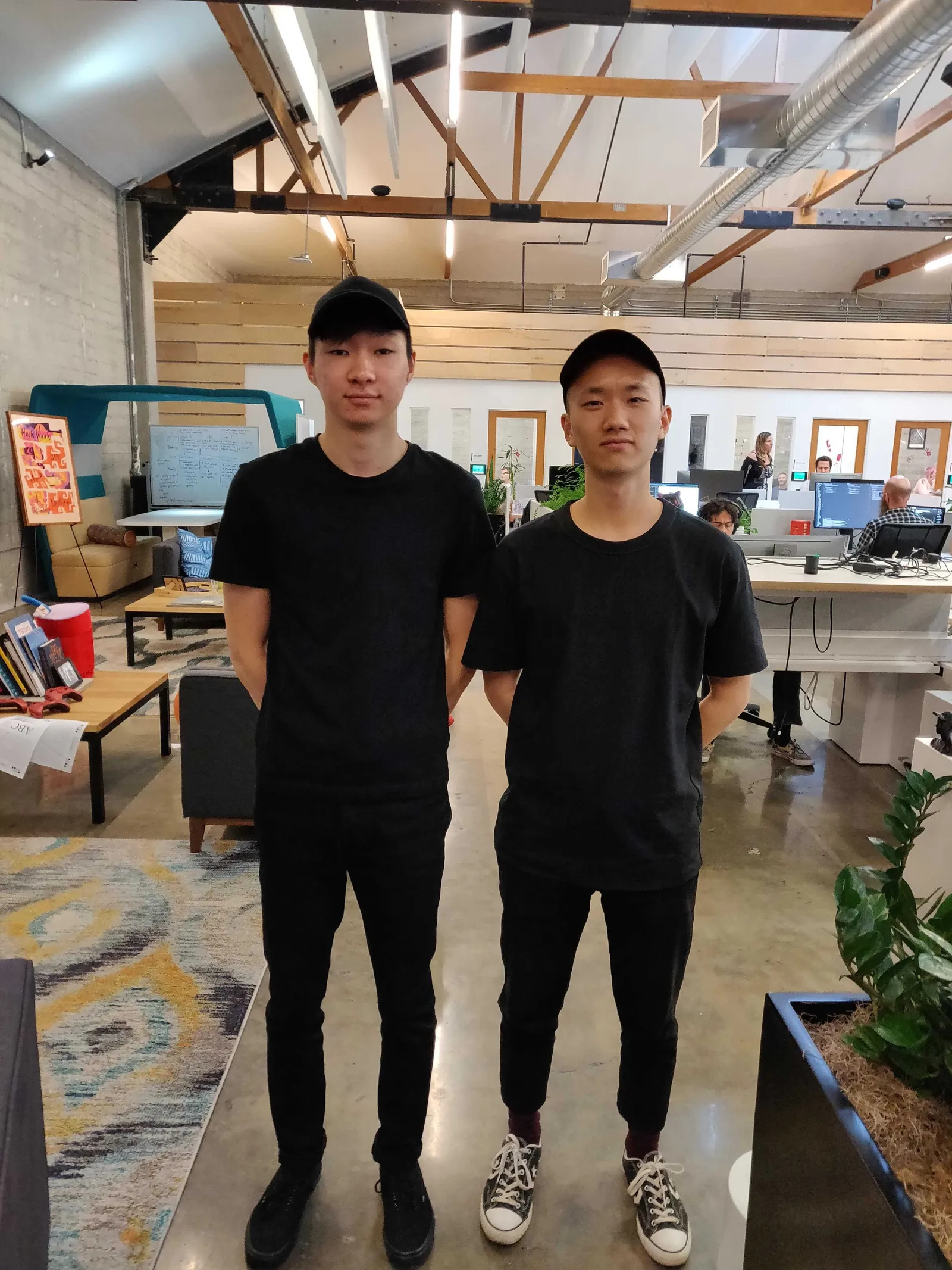 Two Sentry interns wearing matching black outfits posing in the office